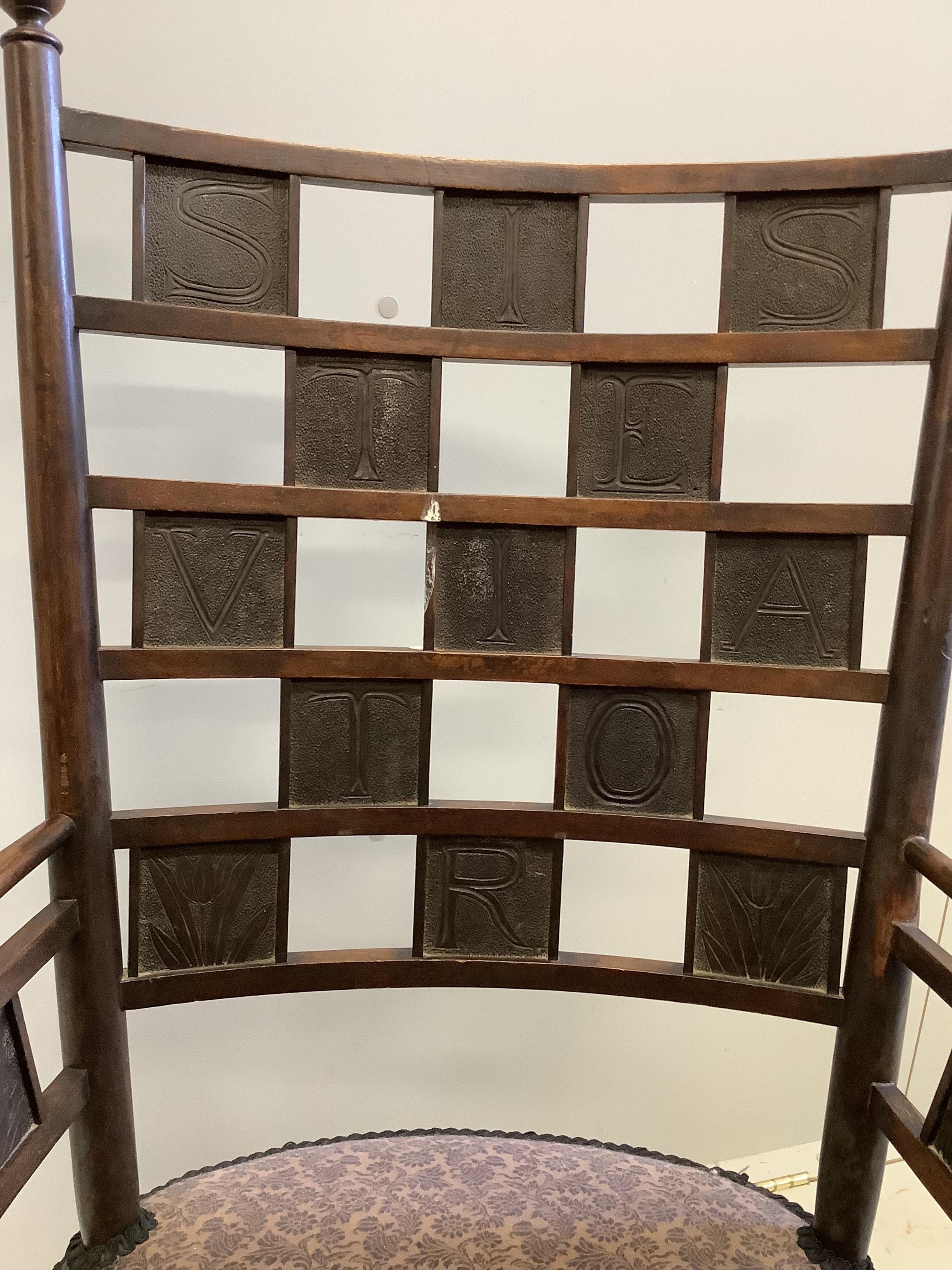 An Arts & Crafts rocking chair, the tablet back with Latin inscription, width 60cm, depth 52cm, height 108cm